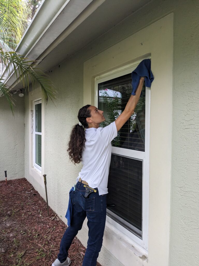 Woman detailing a crystal clean window in Jupiter Farms