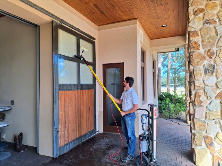 Man cleaning a high up luxury home window