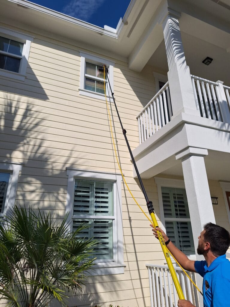 Man in Palm Beach County Cleaning 2nd floor window