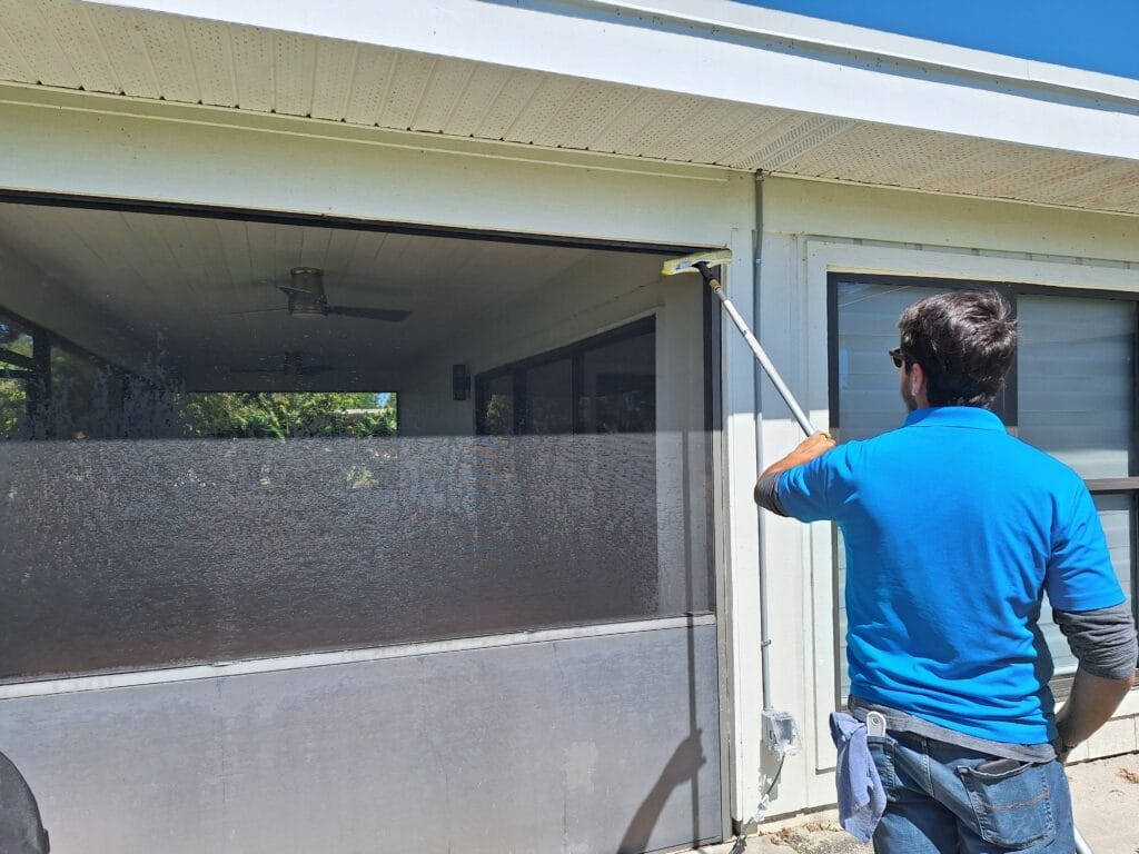 Man Cleaning exterior patio room in PBG Florida