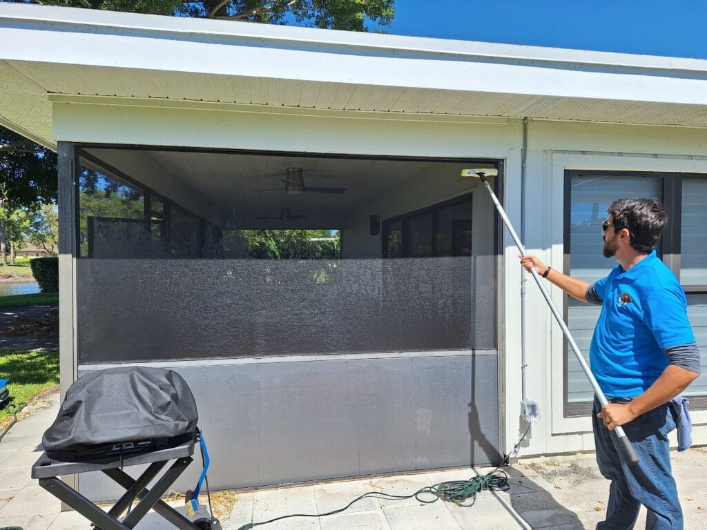 Man cleaning sunroom screen in Palm Beach Gardens