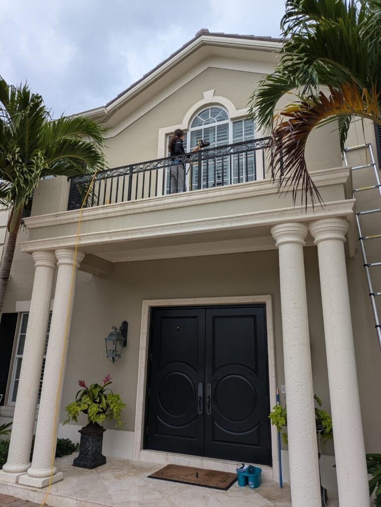 Woman in Lost Tree Cleaning Second Story window