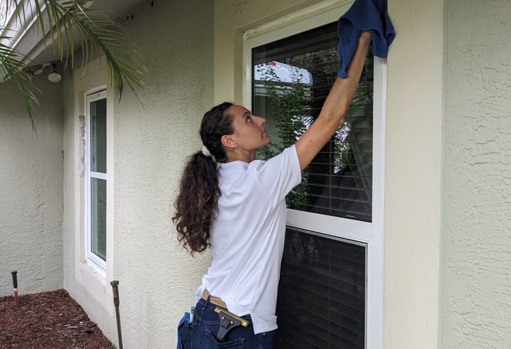 Woman detailing a crystal clean window in Jupiter Farms